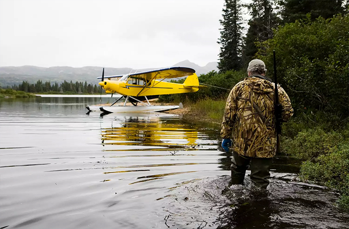 獵人在伊利亞姆納湖與他的妻子橫過(guò)他的肩膀